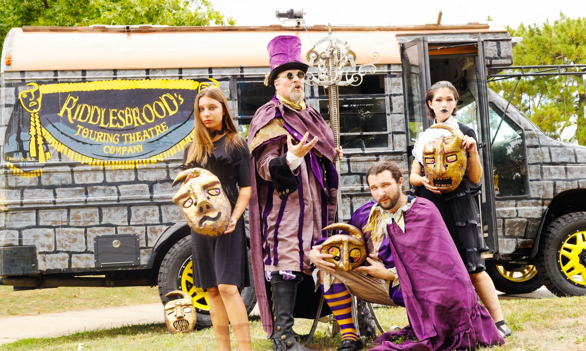 A group of Riddlesbrood actors posing in front of the Castle Bus stage