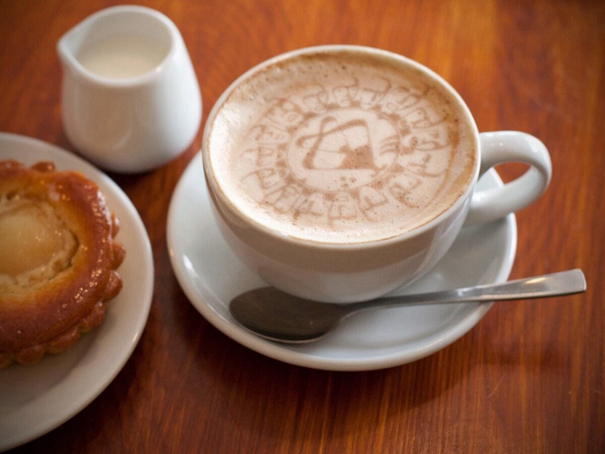 A coffee cup featuring the Riddlesbrood logo, set on a table at a murder mystery event in PA
