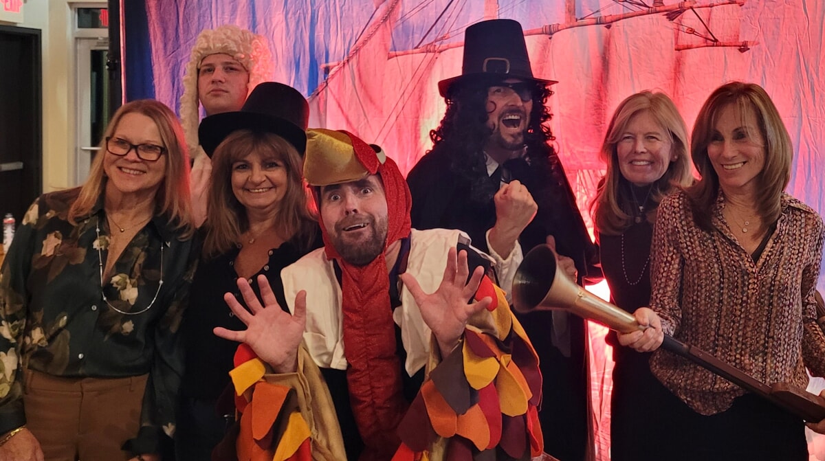 The full cast of "The Mayflower Murder" posing together in period costumes, ready to entertain with a hilarious Thanksgiving murder mystery this November.