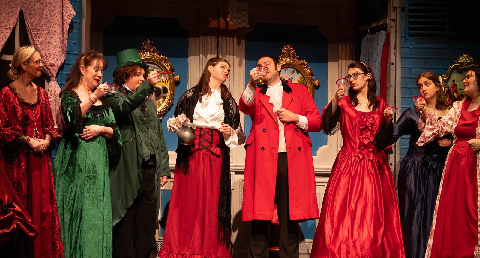 Actors in Victorian costumes singing carols during a national touring theater performance