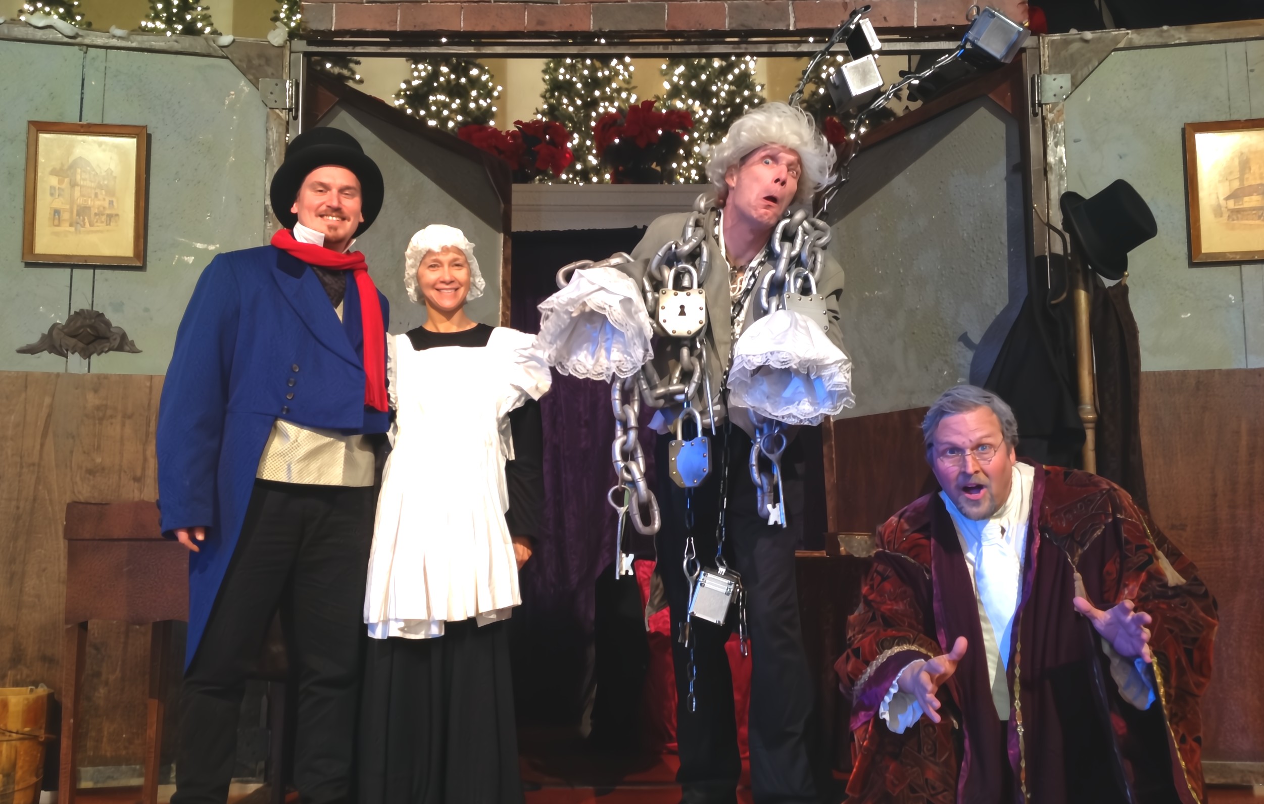 Actors in Dickensian costumes posing for a Christmas Murder Mystery dinner theater event.