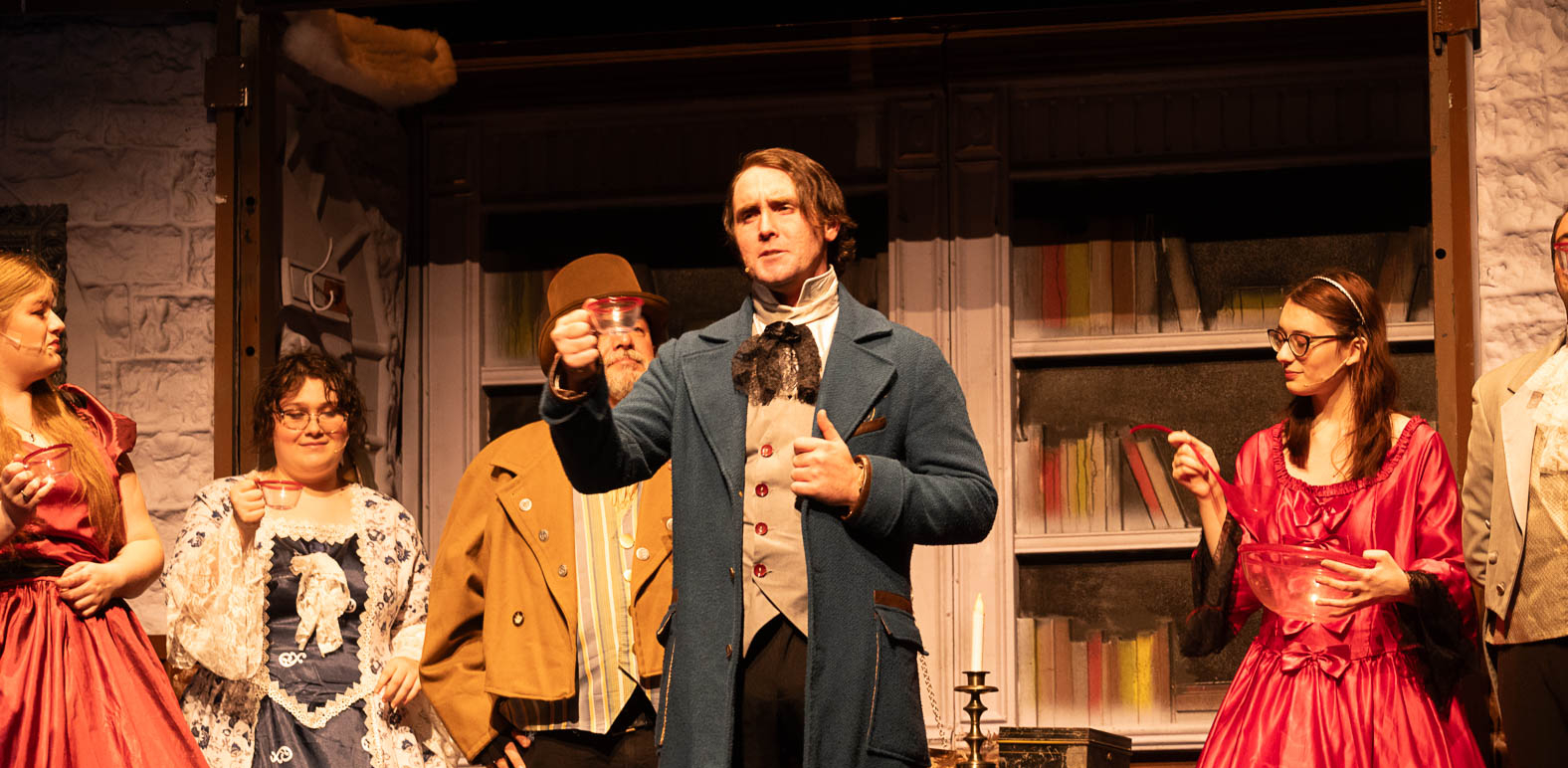Actors performing a lively holiday scene from A Christmas Carol, touring nationally for audiences across the country