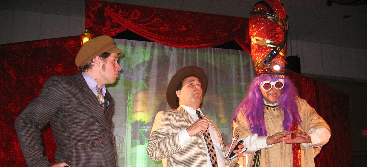 Performers engaging the audience in a funny and mysterious stage production