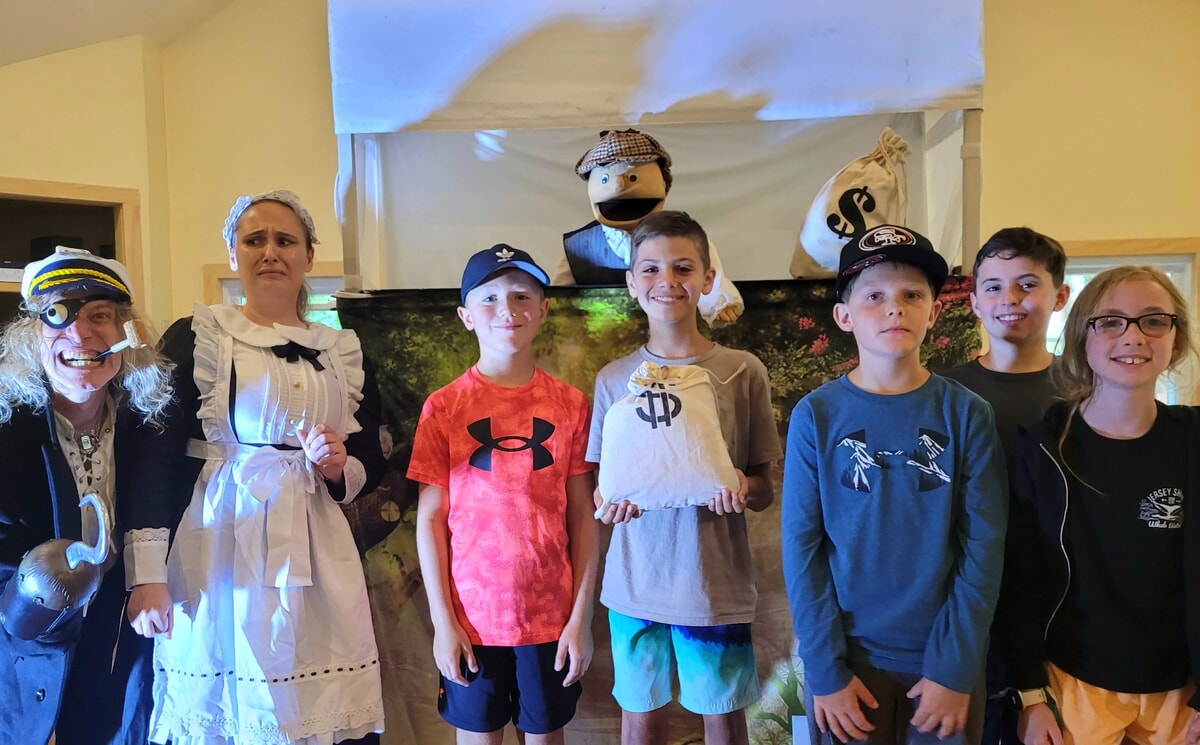 Kids playing games and engaging in creative activities indoors at a summer camp in NJ