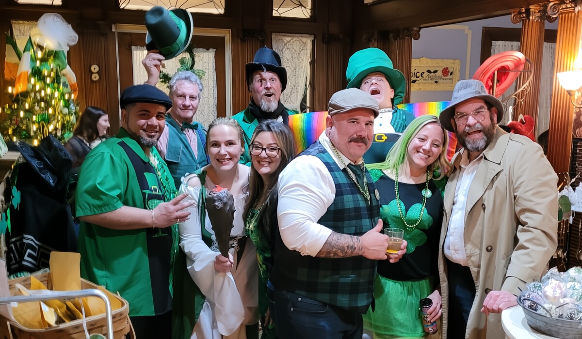 A mischievous leprechaun character grinning while holding a four-leaf clover, central to the mystery in this Irish murder mystery show.