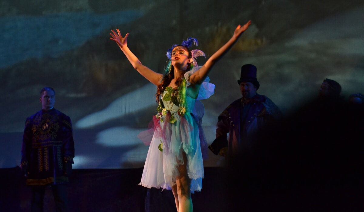 Fairies singing the Riddlesbrood theme song in a theatrical performance, blending music and fantasy.