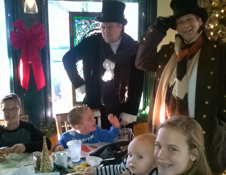 Employees enjoying a live performance of A Christmas Carol at their company Christmas party