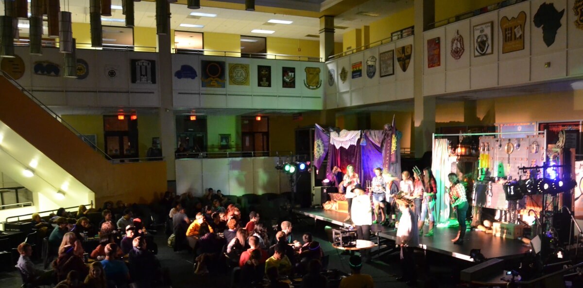 A lively group of students debates whodunit at a college murder mystery party, enjoying the suspense
