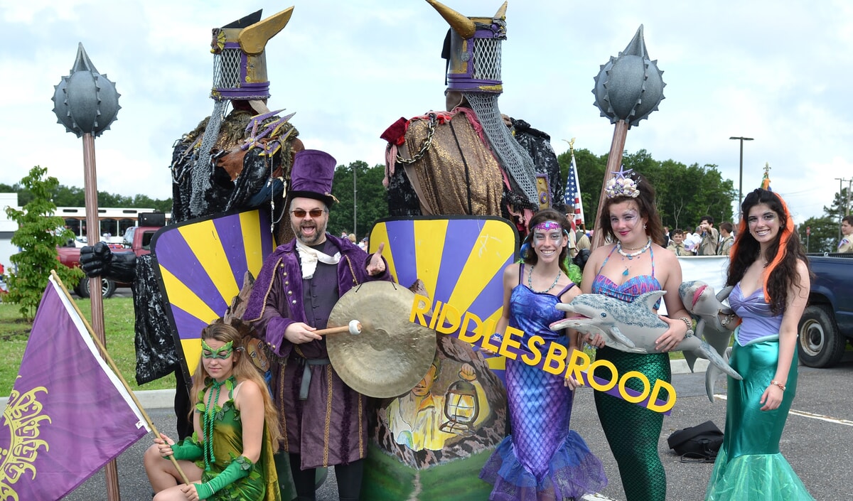 A vibrant parade with families and performers celebrating together, showcasing the spirit of fun community involvement.