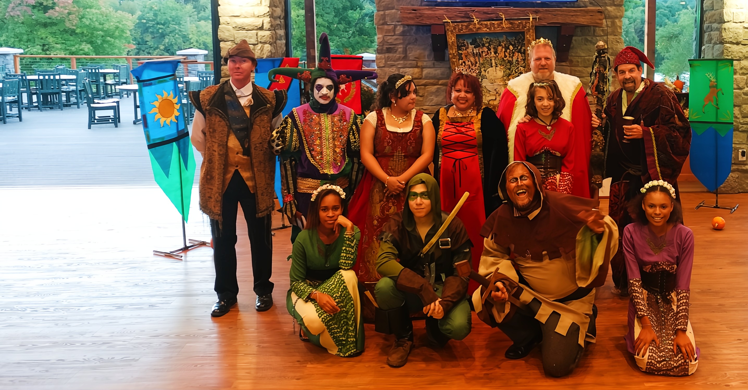 A touring theater troupe performing a comedic scene on an outdoor stage at a festival event.