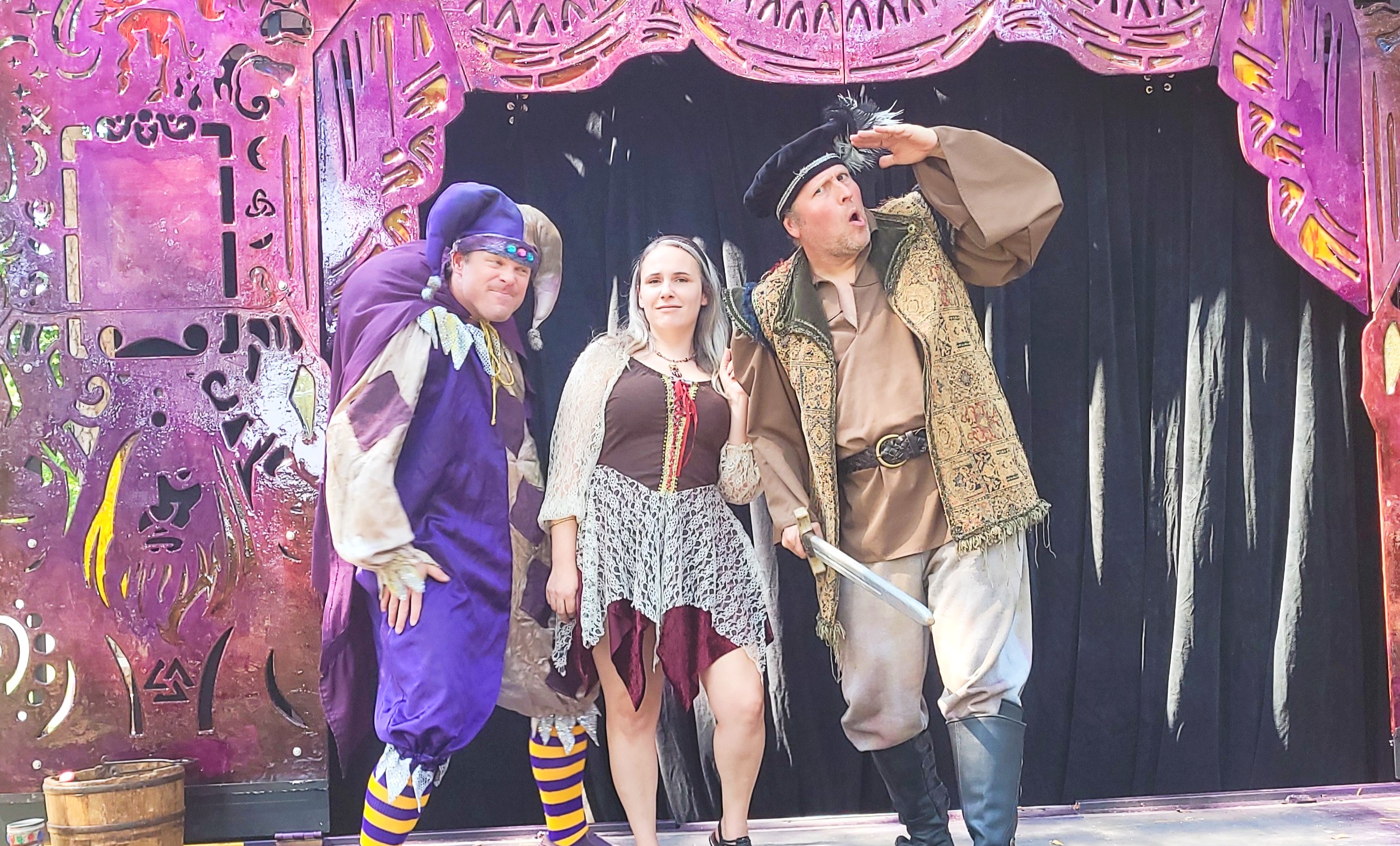 A group of actors delivering a dramatic scene during an outdoor touring theater production