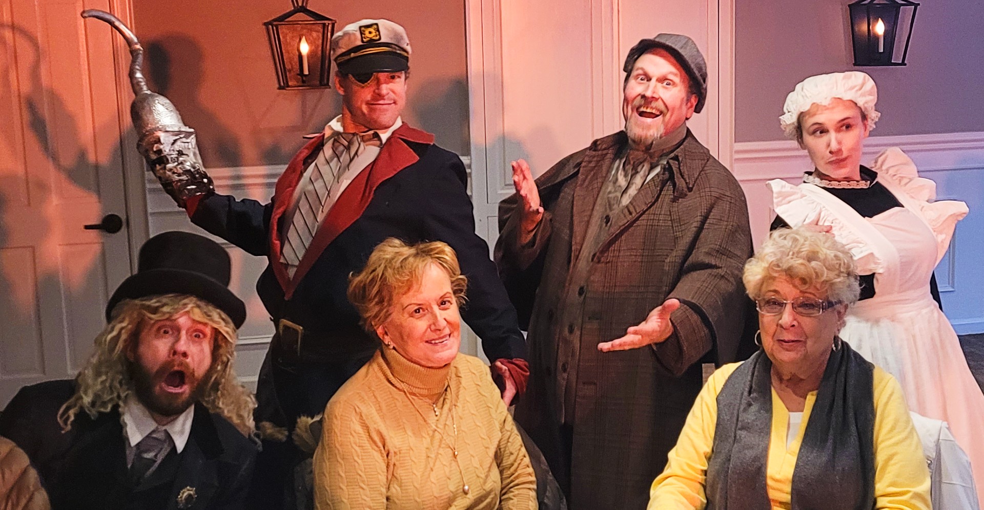 Guests laughing while interacting with costumed actors at a Peddlers Murder Mystery Party.