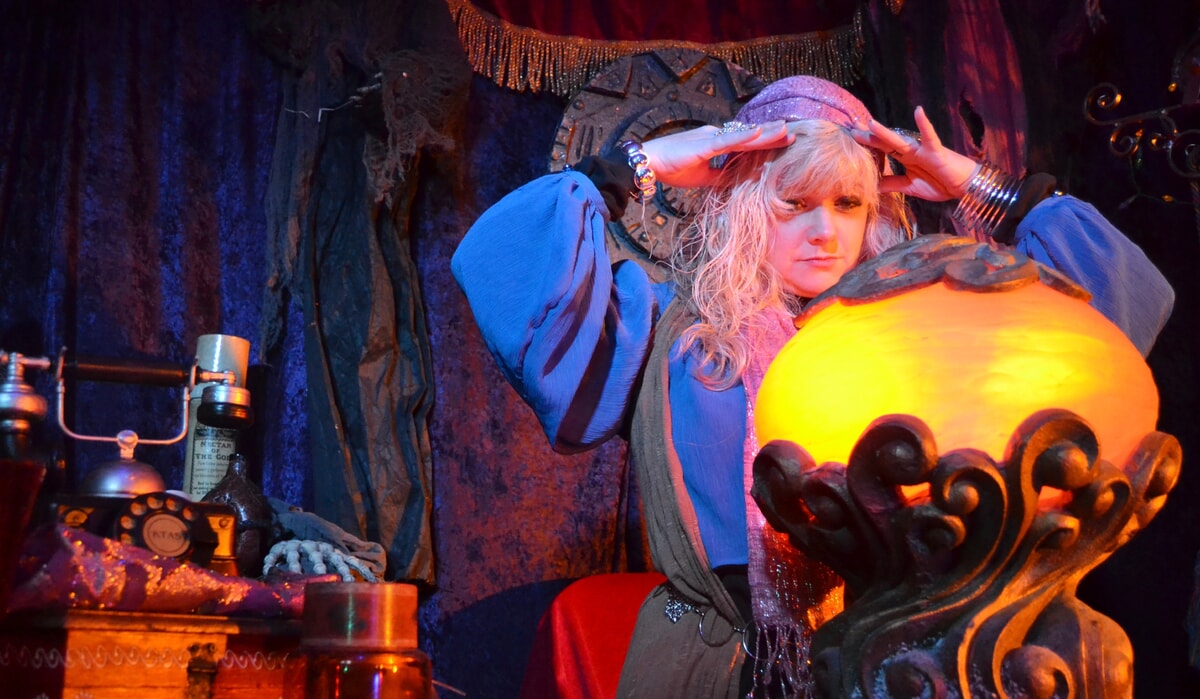 Psychic Madame Cluedefti holding a glowing crystal ball, revealing clues in a murder mystery