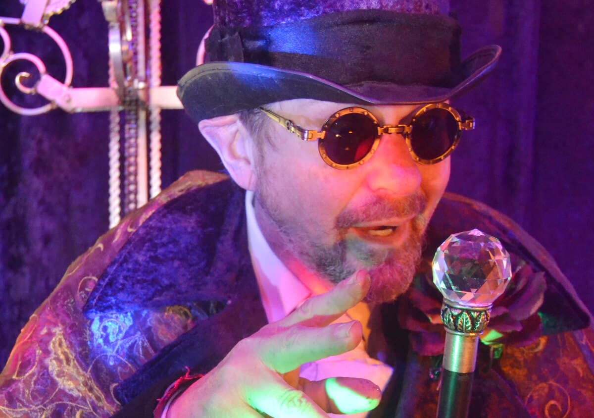 A close-up of Clyde P. Riddlesbrood's piercing eyes beneath the brim of his signature hat