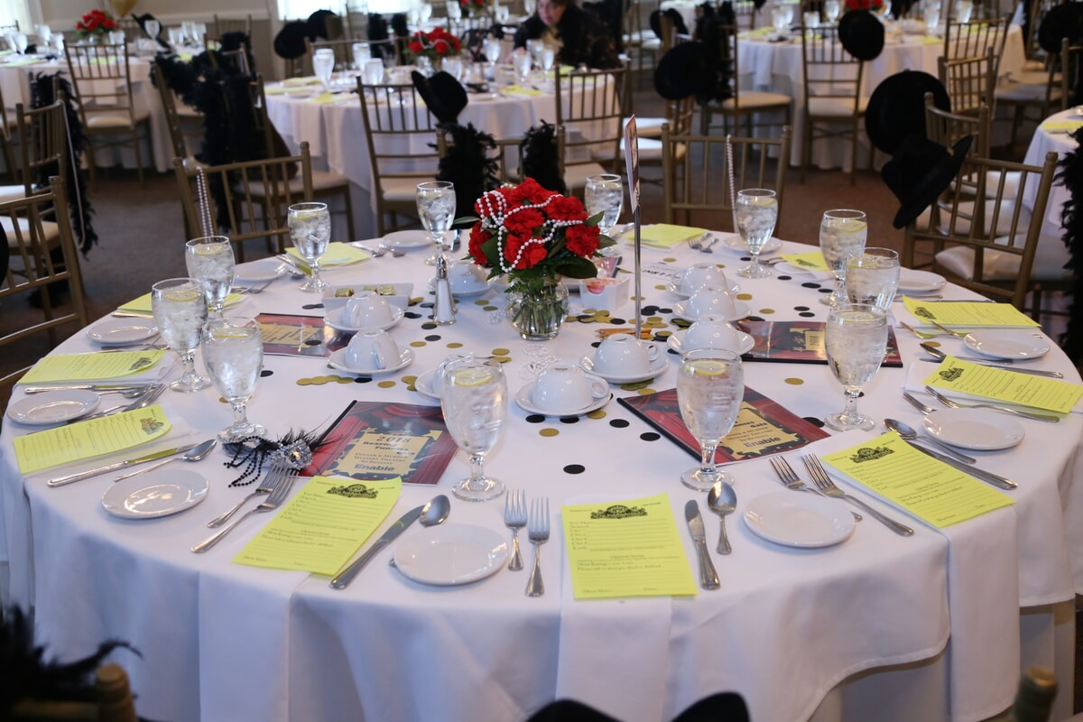 Murder mystery dinner table with detective-themed decorations, clue cards, and vintage-style centerpieces.