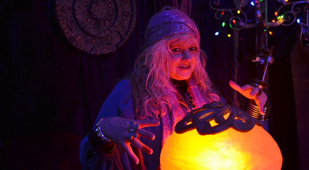 Madame Cluedefti dramatically unveils a clue at a murder mystery party, revealing the secrets to a great interactive experience