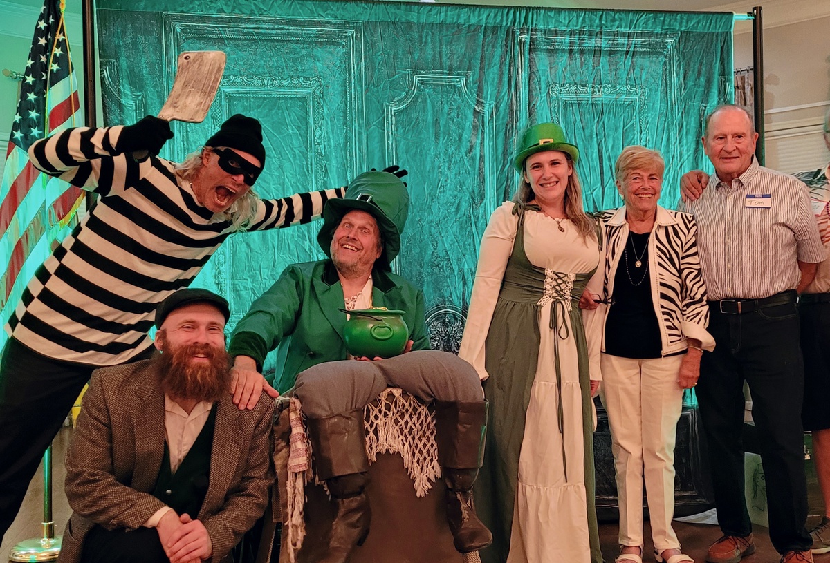 The full cast of "The Four-Leaf Killer" murder mystery posing together—detective, leprechaun, and Irish-dressed woman—all looking suspicious.