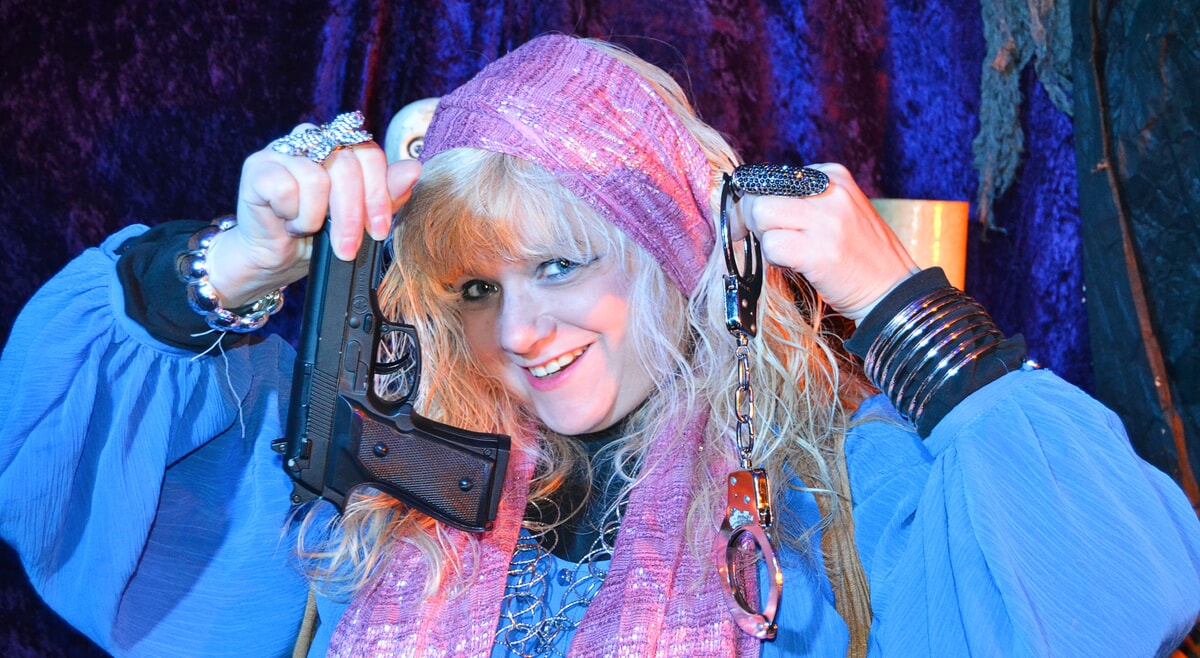 With a knowing gaze, Madame Cluedefti unveils a cryptic clue at a thrilling adult murder mystery event