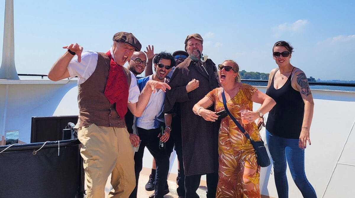 Guests enjoying a summer murder mystery dinner party in an open-air setting