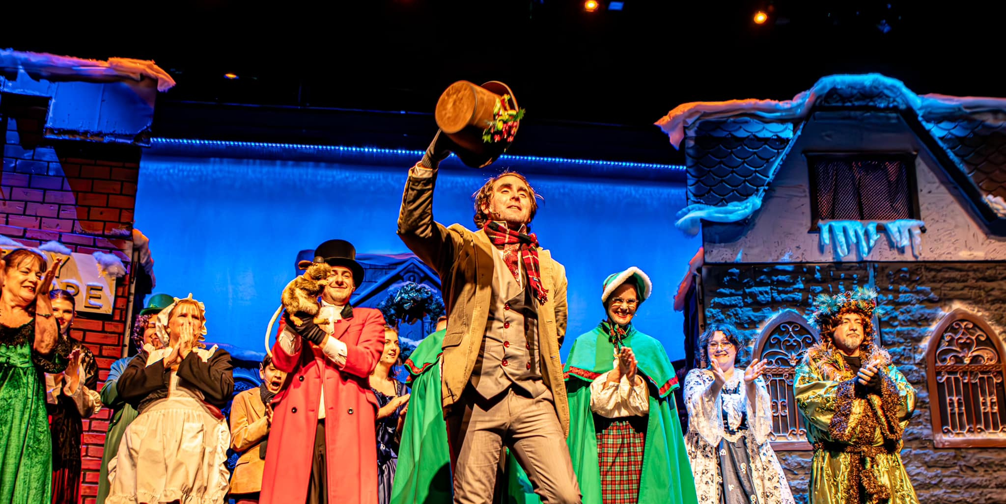 Actors in period costumes performing A Christmas Carol as part of a national touring theater production