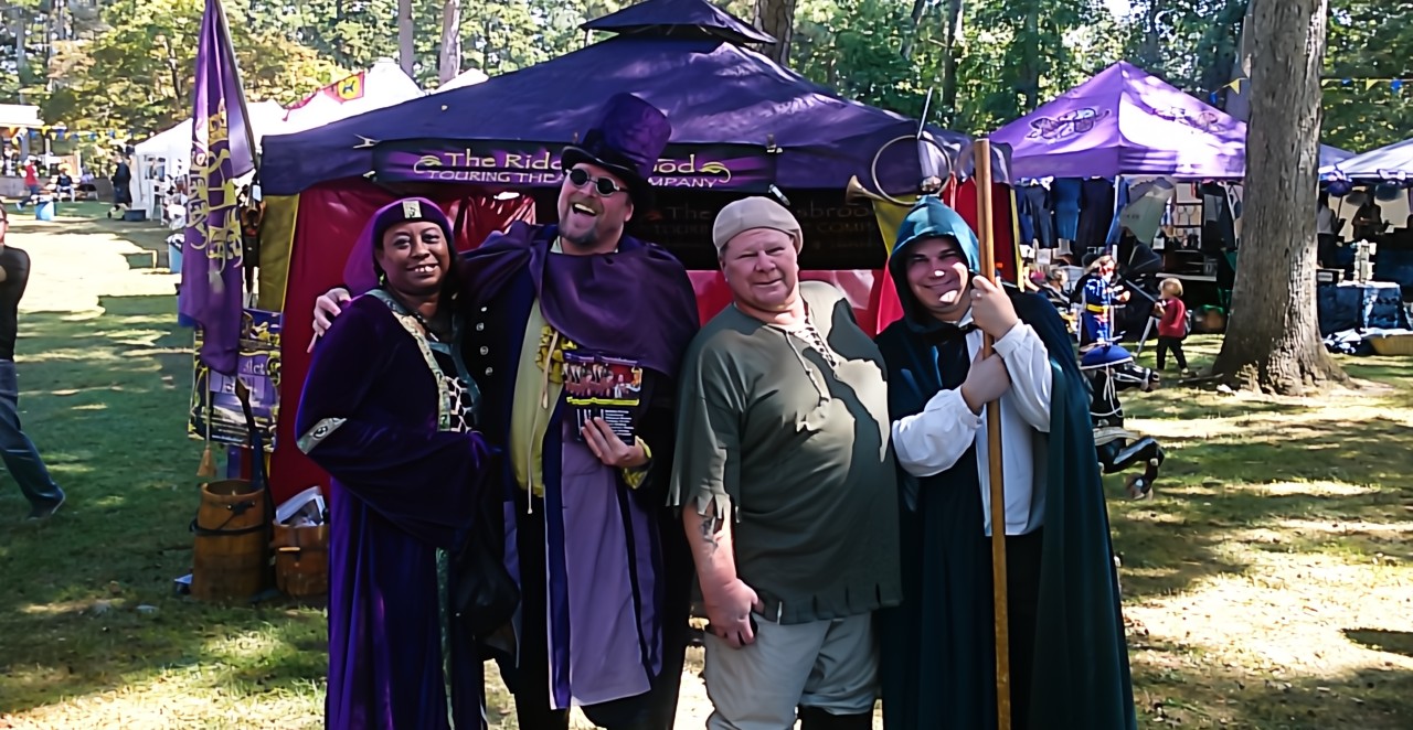A lively outdoor theater performance with costumed actors entertaining an audience in a park setting