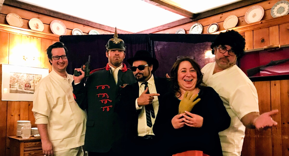 Audience members questioning a suspect during a murder mystery performance