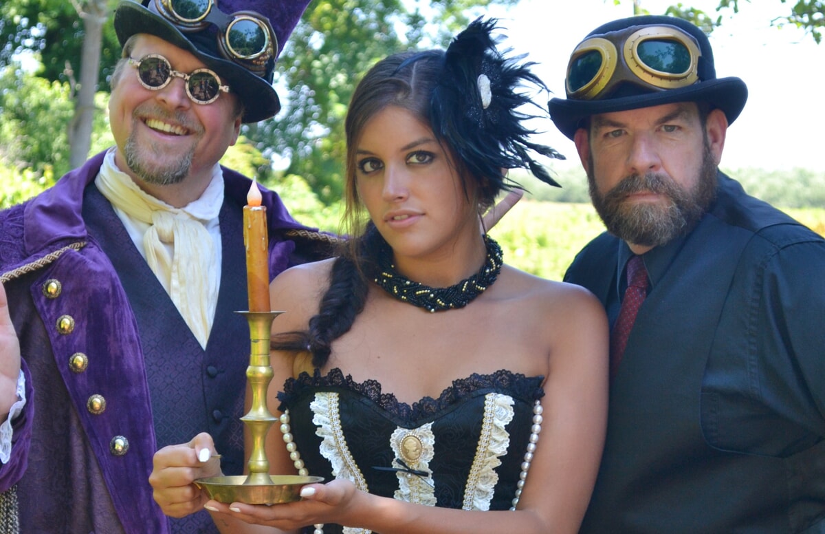 Clyde P. Riddlesbrood, a puppeteer, and a talented actress posing together, representing Riddlesbrood’s values on theatrical content and immersive storytelling