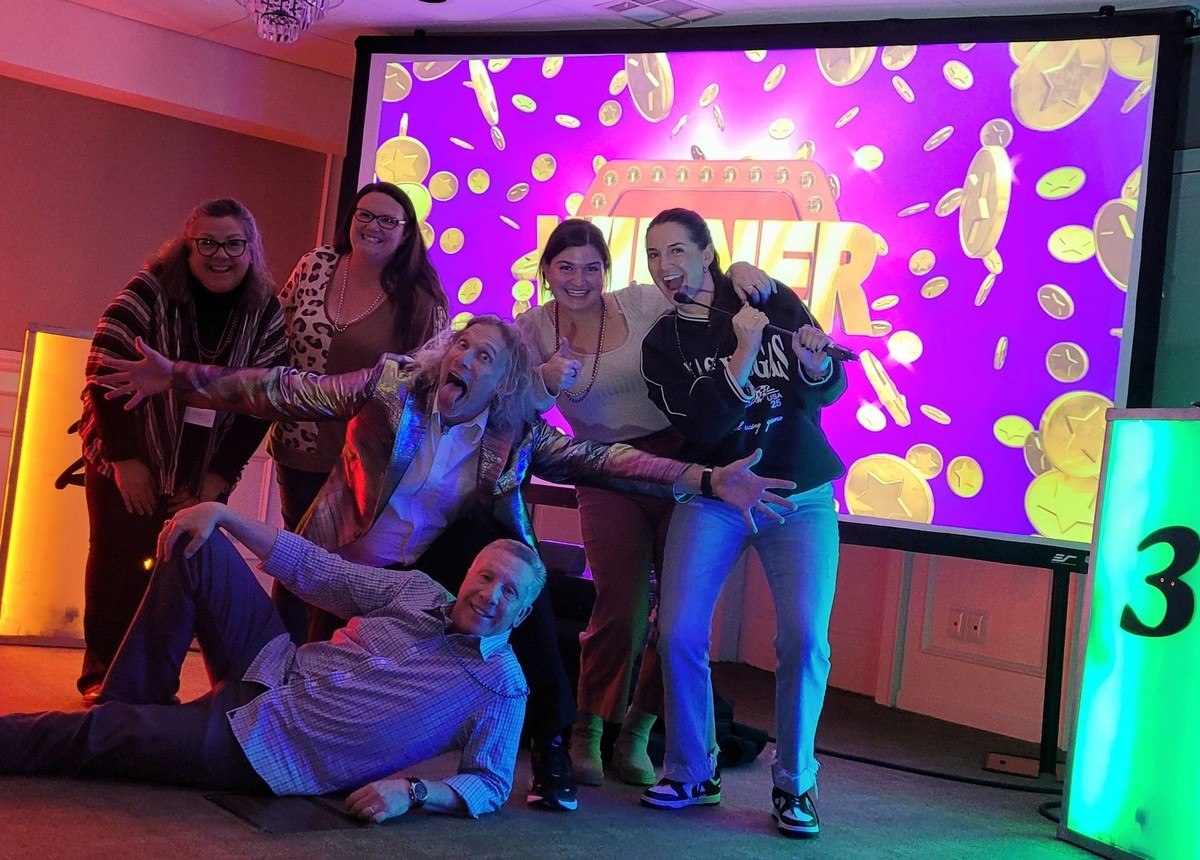 A lively moment from a touring game show, featuring an enthusiastic host and contestants.