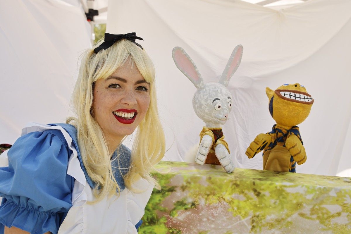 A vibrant scene from a touring kids' show featuring colorful characters and fantastical storytelling